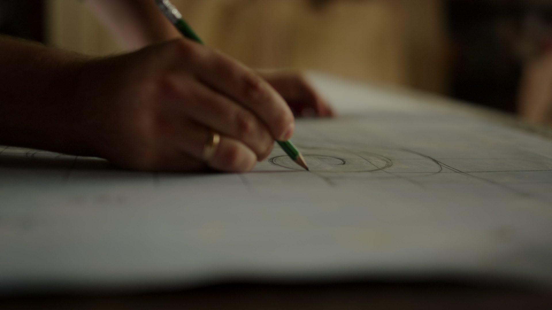 Mão desenhando a lápis sobre uma folha de projeto